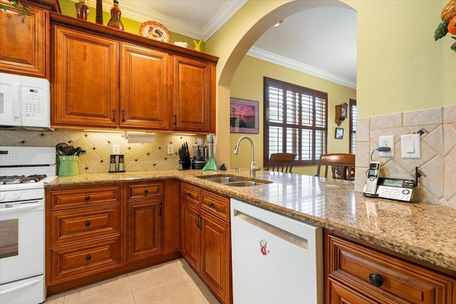 225 SW Coconut Key Way, Port Saint Lucie, FL 34986 - kitchen featuring white appliances, a sink, arched walkways, light stone counters, and ornamental molding