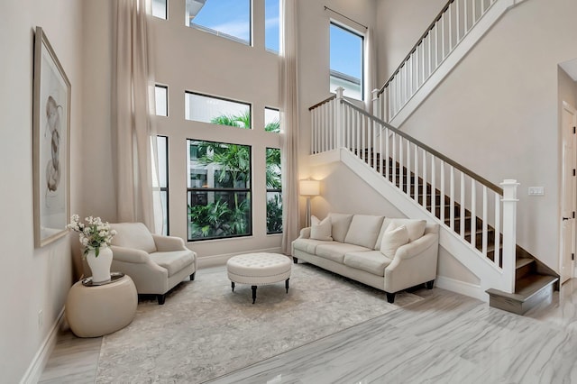 living room with baseboards, a high ceiling, and stairs