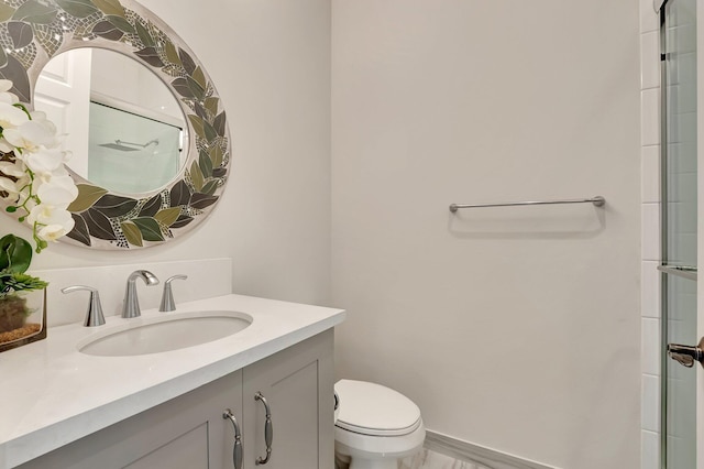 bathroom featuring toilet, a shower with door, and vanity