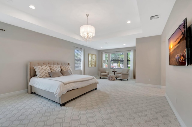 bedroom with a raised ceiling, light colored carpet, visible vents, a chandelier, and baseboards