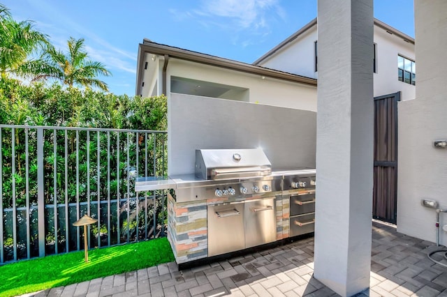 view of patio with exterior kitchen and fence