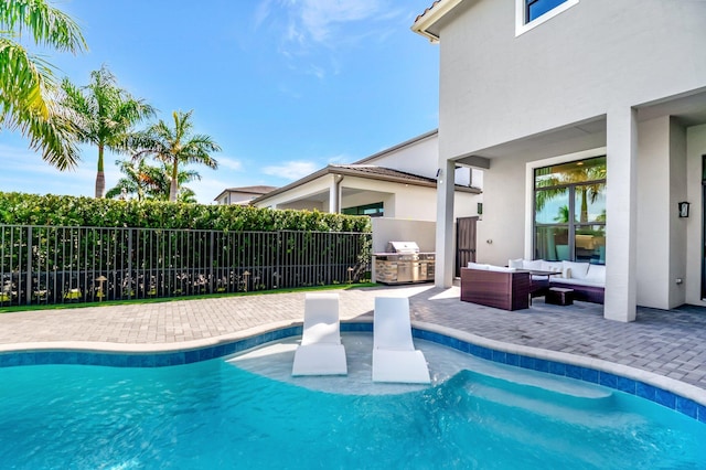 view of swimming pool featuring area for grilling, a patio area, fence, exterior kitchen, and an outdoor living space