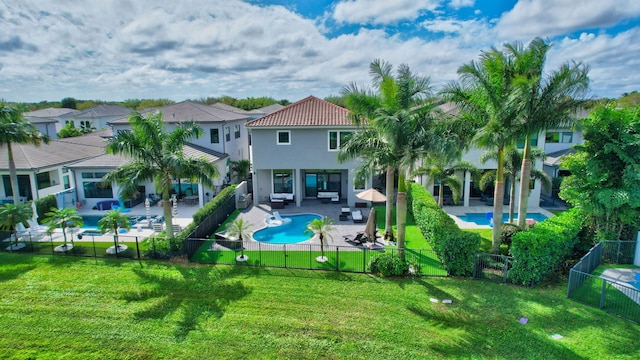 back of house with a fenced in pool, a patio area, a fenced backyard, and stucco siding