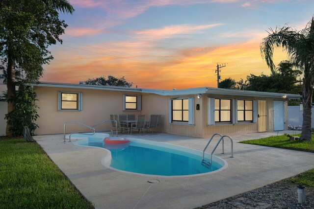 rear view of house with a patio and an outdoor pool