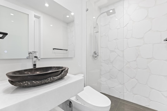 bathroom featuring a shower, tile patterned floors, toilet, and sink