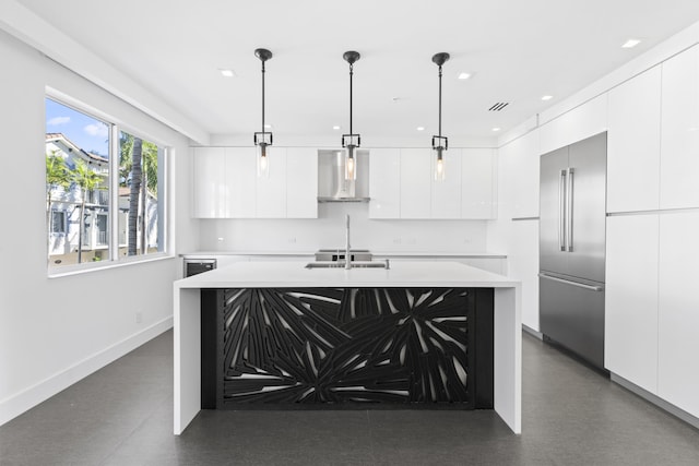 kitchen with pendant lighting, exhaust hood, stainless steel built in fridge, an island with sink, and white cabinetry