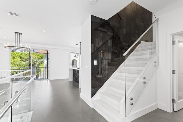 stairs featuring a chandelier