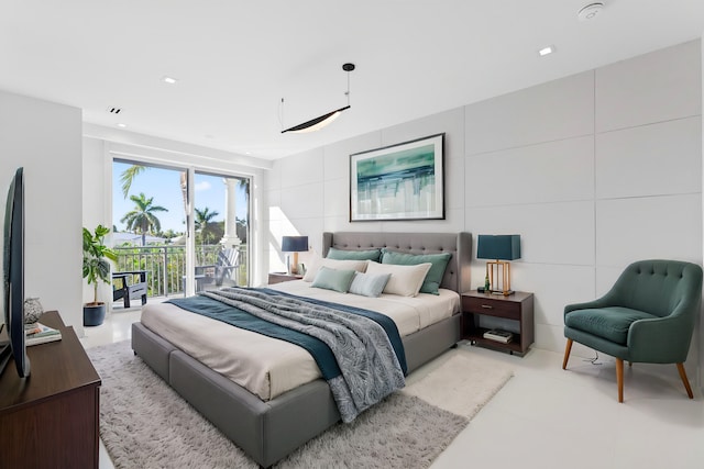 bedroom featuring tile walls and access to outside