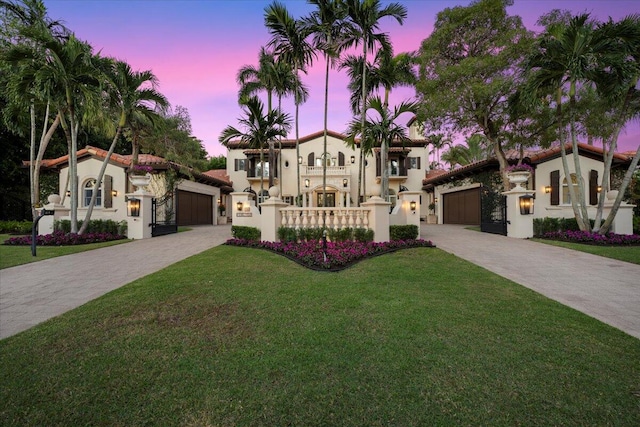 mediterranean / spanish house featuring a lawn, a balcony, and a garage