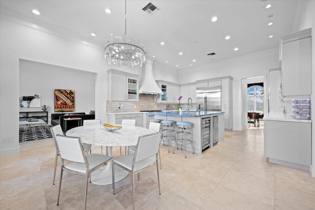 dining space featuring light tile patterned floors, wine cooler, and crown molding