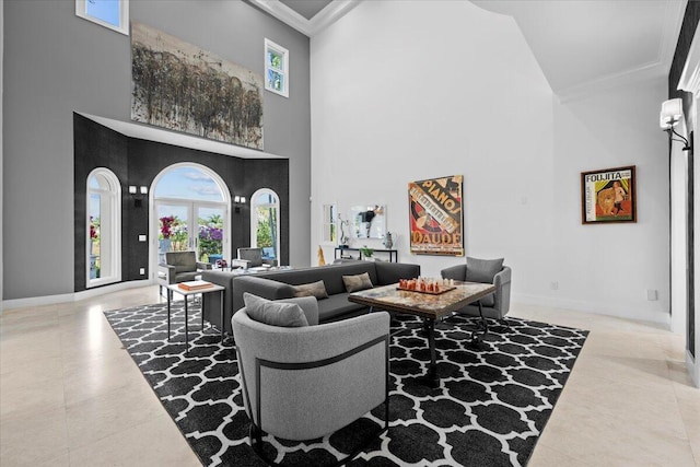 living room with light tile patterned flooring, a towering ceiling, and ornamental molding