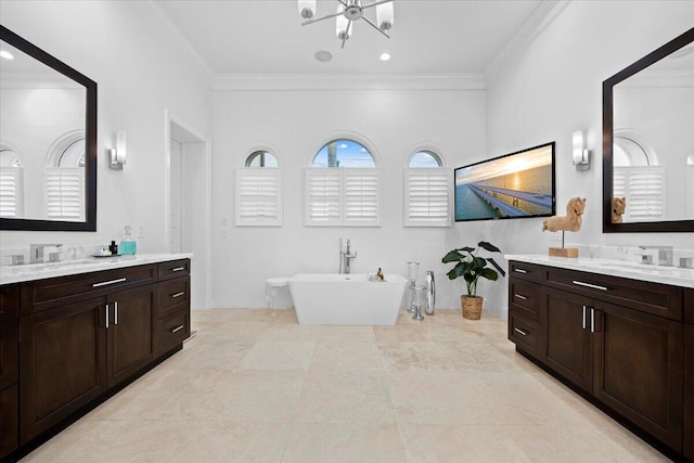 bathroom with vanity, a tub to relax in, and ornamental molding