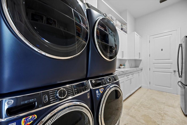 washroom with washing machine and clothes dryer, cabinets, and stacked washer and clothes dryer