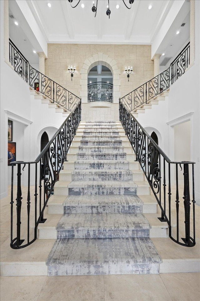 stairs featuring beamed ceiling and a high ceiling