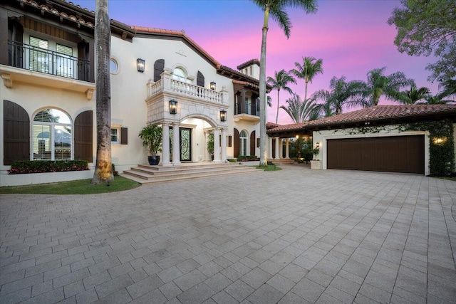 mediterranean / spanish house with a garage and a balcony