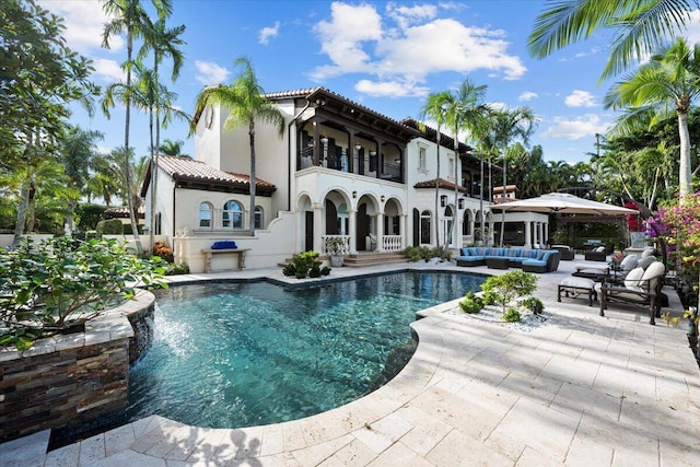 back of property featuring outdoor lounge area, a patio area, and a balcony