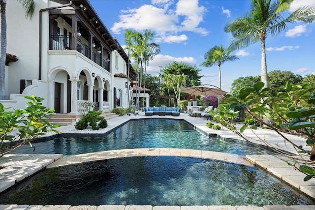 view of pool with an outdoor living space and a patio area