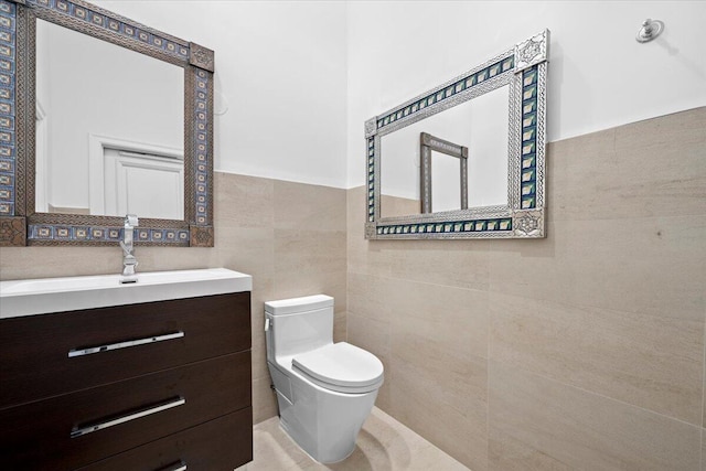 bathroom featuring vanity, tile walls, and toilet