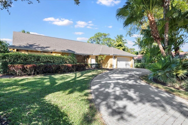 ranch-style home with a garage and a front lawn