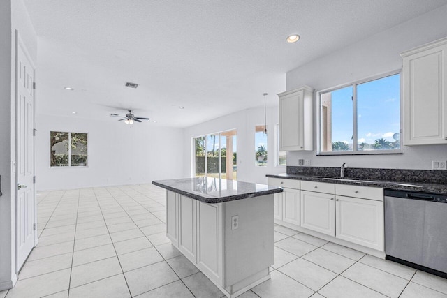 kitchen featuring white cabinets, ceiling fan, dishwasher, a center island, and hanging light fixtures