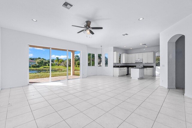 unfurnished living room featuring ceiling fan and light tile patterned floors