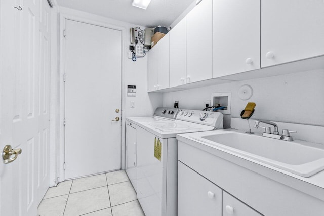 laundry area with sink, cabinets, a textured ceiling, light tile patterned flooring, and washer and dryer