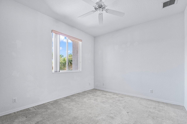 carpeted spare room with ceiling fan and a textured ceiling