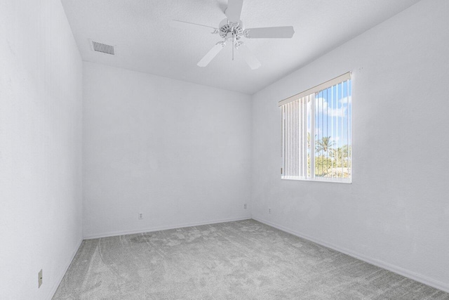 carpeted spare room with ceiling fan