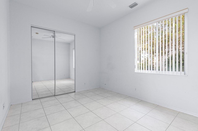 unfurnished bedroom with ceiling fan and a closet