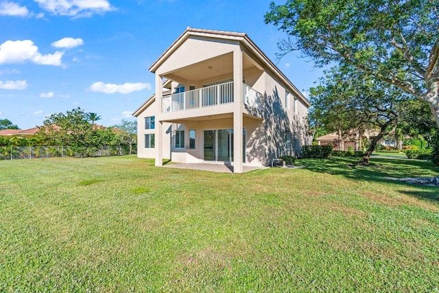 back of property featuring a lawn and a balcony