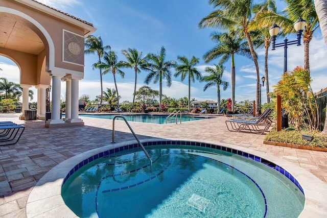 view of swimming pool featuring a hot tub and a patio