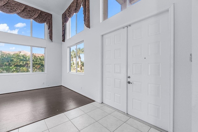 tiled foyer entrance featuring a towering ceiling