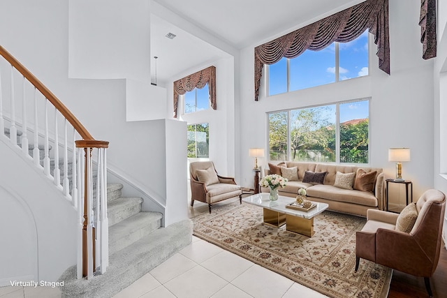 living room featuring a towering ceiling and light tile patterned floors