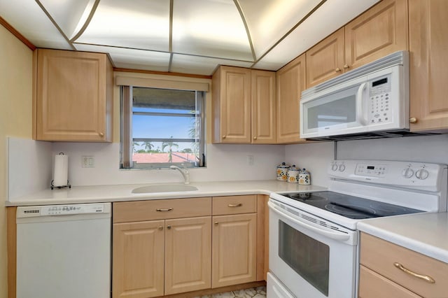 kitchen featuring light brown cabinetry, white appliances, and sink