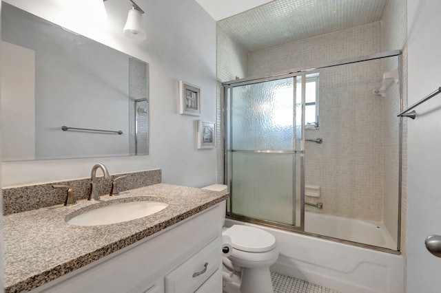 full bathroom featuring tile patterned floors, vanity, toilet, and enclosed tub / shower combo