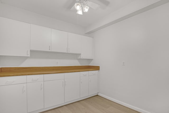 kitchen featuring white cabinets, ceiling fan, wood counters, and light wood-type flooring