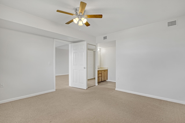 unfurnished bedroom featuring ensuite bathroom, ceiling fan, and light colored carpet