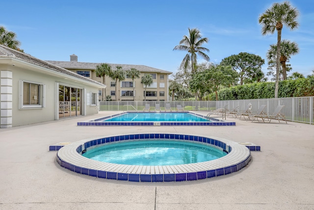 view of pool with a community hot tub and a patio