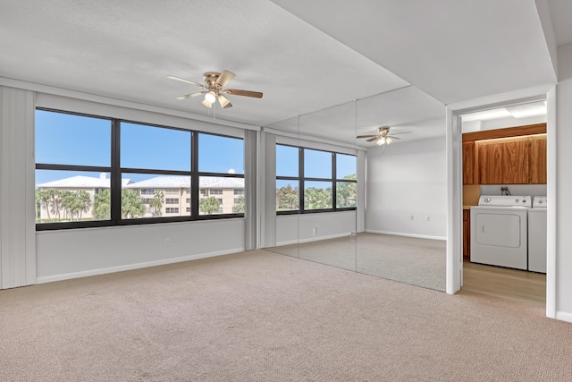 unfurnished bedroom with ceiling fan, independent washer and dryer, light carpet, and multiple windows