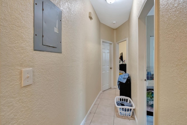 hallway with electric panel and light tile patterned floors