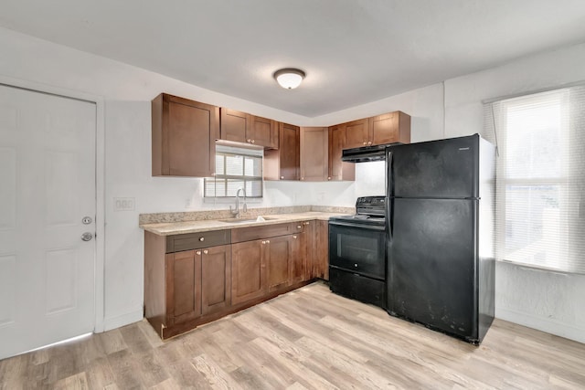 kitchen featuring black appliances, plenty of natural light, and light wood-type flooring