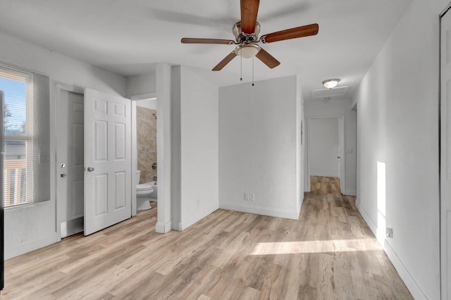 interior space with connected bathroom, light hardwood / wood-style flooring, and ceiling fan