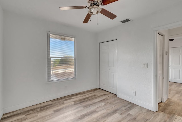 unfurnished bedroom with a closet, light hardwood / wood-style floors, and ceiling fan