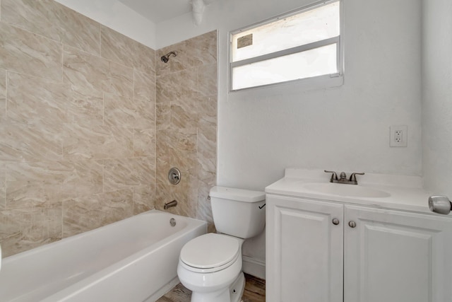 full bathroom with tiled shower / bath, vanity, and toilet