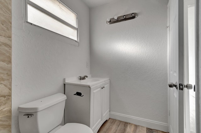 bathroom featuring toilet, vanity, and hardwood / wood-style flooring