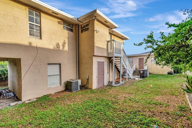 back of house featuring a lawn and central AC