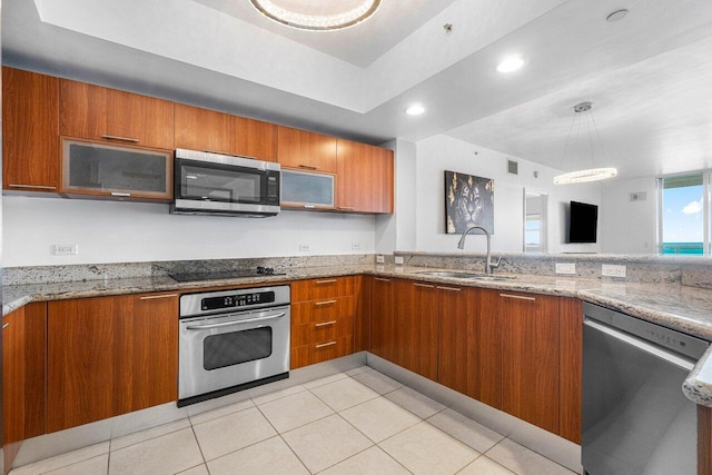 kitchen featuring light stone countertops, sink, light tile patterned flooring, and stainless steel appliances