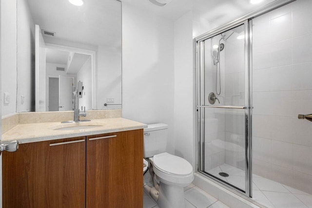 bathroom with tile patterned flooring, vanity, toilet, and a shower with shower door