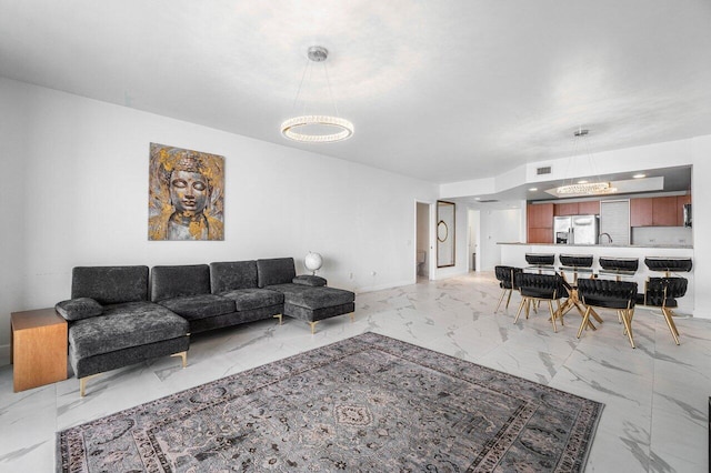 living room with a notable chandelier and sink