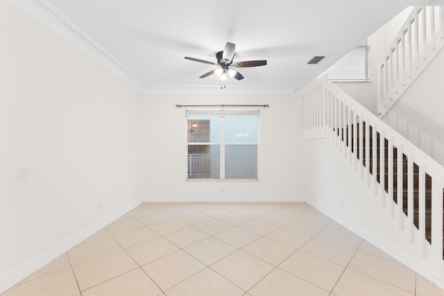 empty room featuring ceiling fan, light tile patterned flooring, and ornamental molding